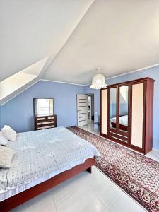 a bedroom with blue walls and a large bed at Двухэтажный коттедж с 2 апартаментами на озере in Dolinka