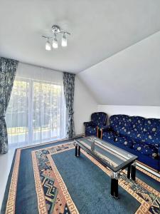 a living room with a couch and a table at Двухэтажный коттедж с 2 апартаментами на озере in Dolinka