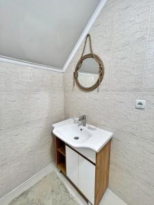 a bathroom with a sink and a mirror at Двухэтажный коттедж с 2 апартаментами на озере in Dolinka