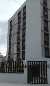 un edificio con puertas negras delante de él en Residencial El Trenet 2A, en Benicàssim