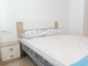 um quarto com uma cama com duas almofadas em Residencial El Trenet 2A em Benicàssim