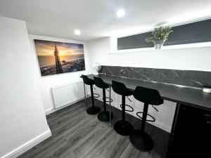 a room with a bar with stools in it at new osborne luxury Hottub and jacuzzi suites in Blackpool