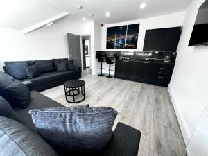 a living room with a couch and a kitchen at new osborne luxury Hottub and jacuzzi suites in Blackpool