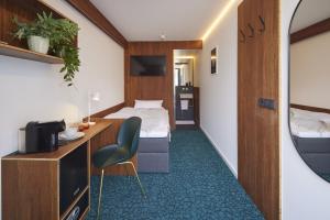 a hotel room with a bed and a desk and a chair at TIN INN Montabaur l einfach gut - nachhaltig, innovativ, modern in Montabaur