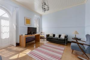 a living room with a couch and a television at Casa Dorothea in Cercal