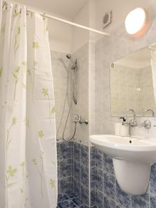 uma casa de banho com um lavatório e uma cortina de chuveiro em Mint Family Hotel em Ravda