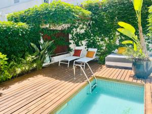 einen Pool mit zwei Stühlen und einem Bett im Hof in der Unterkunft Swimming pool Apartment Central Lisbon in Lissabon
