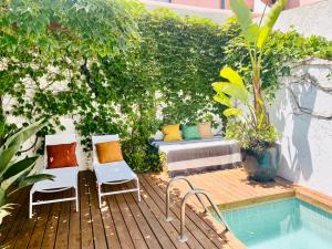 eine Terrasse mit Stühlen und einer Bank neben einem Pool in der Unterkunft Swimming pool Apartment Central Lisbon in Lissabon