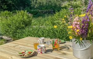 una mesa de madera con bebidas y un jarrón de flores en Stunning Home In Tonstad With Kitchen en Tjørhom