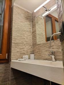 ein Bad mit einem Waschbecken und einem Spiegel in der Unterkunft Hotel Camilla Guelfa in Florenz