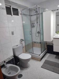 y baño con ducha, aseo y lavamanos. en Apartamento en Playa Carvajal, en Fuengirola