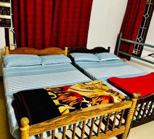 two beds sitting next to each other in a bedroom at La Paz Coorg homestay at Madikeri town in Madikeri