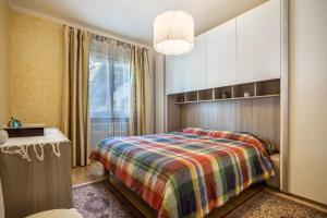 a bedroom with a bed with a colorful blanket at Villa Vittoria Mountain View in Breguzzo