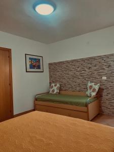 1 dormitorio con cama y pared de ladrillo en Villa Elvira, en Vieste