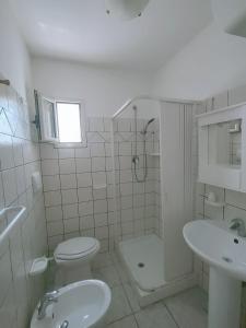 Baño blanco con aseo y lavamanos en Villa Elvira, en Vieste