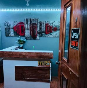una habitación con tres cabinas de teléfono rojo en la pared en RJ Travellers Inn, en Catbalogan