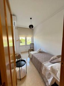 a bedroom with two beds and a chair and a window at Piso centro Arenas: Mira Gredos in Arenas de San Pedro