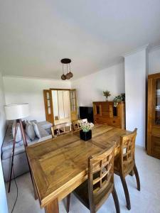 Una sala de estar con una mesa y sillas de madera. en Piso centro Arenas: Mira Gredos, en Arenas de San Pedro