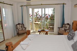 1 dormitorio con cama, sillas y ventana grande en Villa Tulip, en Kalkan