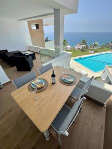a dining table and chairs in a living room with a pool at THE SEA VIEW CALACEITE in Torrox Costa