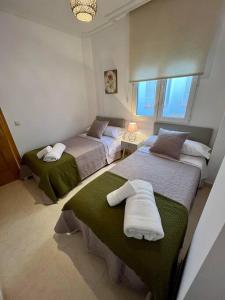 um quarto com 2 camas e toalhas em Piso centro Arenas: Mira Gredos em Arenas de San Pedro