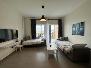 uma sala de estar com um sofá e uma televisão em Dead Sea view Elite apartment Samara Resort traveler award 2024 em Sowayma