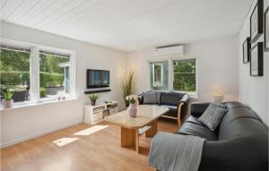 salon z czarną skórzaną kanapą i stołem w obiekcie 2 Bedroom Gorgeous Home In Vordingborg w mieście Vordingborg