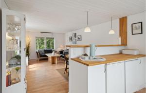 een keuken en een woonkamer met witte muren en houten vloeren bij 2 Bedroom Gorgeous Home In Vordingborg in Vordingborg