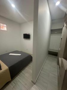 a bedroom with a bed and a tv on the wall at Apartamento Amoblado 3 habitaciones en Barrio La Campiña in Cartagena de Indias