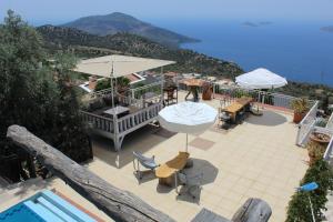 un patio con mesas y sombrillas junto a una piscina en Villa Tulip, en Kalkan