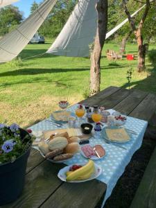 een picknicktafel met borden en glazen sinaasappelsap bij Hoeve de Snippert in Groenlo
