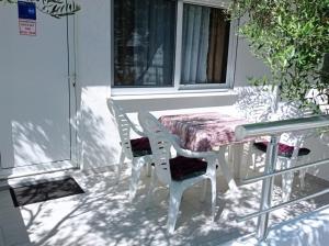 a table and chairs on a porch with a table and a window at Apartments Doha in Ulcinj