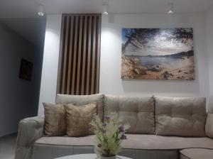 a living room with a couch and a painting on the wall at Apartments Doha in Ulcinj