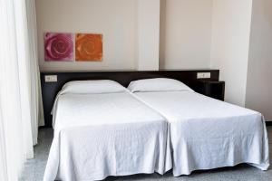 Un dormitorio con dos camas con sábanas blancas. en Espanya - 30º hotels, en Calella 45 fotos más