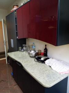 a kitchen with a counter top with red cabinets at Appartment Center in Sarajevo