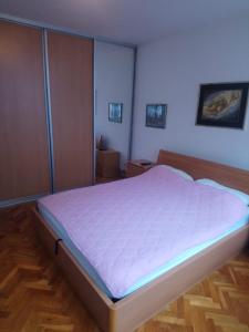 a bedroom with a large bed with purple sheets at Appartment Center in Sarajevo