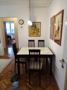 ein Esszimmer mit einem Tisch, Stühlen und einer Uhr in der Unterkunft Appartment Center in Sarajevo