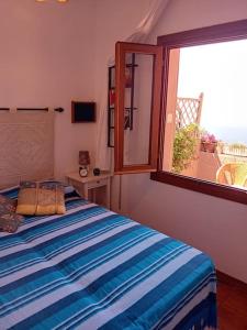 a bedroom with a bed and a window at Belvedere-InfinityHolidays in Costa Paradiso