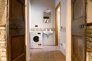 een badkamer met een wasmachine en een wastafel bij Loft nel cuore di Assisi - 50 mt da Carlo Acutis in Assisi