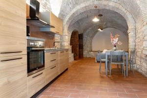 een keuken met een tafel en een stenen muur bij Loft nel cuore di Assisi - 50 mt da Carlo Acutis in Assisi