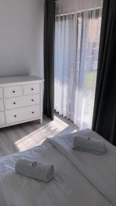 2 almohadas en una cama en un dormitorio con ventana en Casa del Sol Władysławowo, en Władysławowo