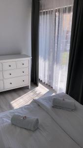 two pillows on a bed in a bedroom with a window at Casa del Sol Władysławowo in Władysławowo