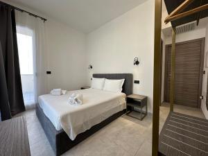 Un dormitorio con una gran cama blanca y una ventana en Dolmen Guest House, en Alghero