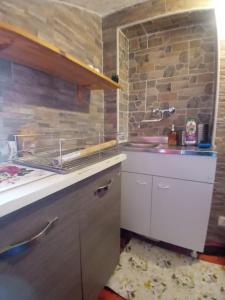 a kitchen with a stove and a stone wall at CASA VACANZA LA MANSARDINA in Pavia