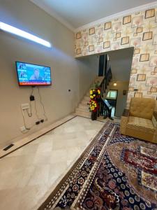 un salon avec un canapé et une télévision sur un mur dans l'établissement Family lodges, à Islamabad 30 autres photos