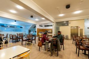 dos personas sentadas en mesas en un restaurante en Posada del Arriero -Hotel, en Chachapoyas