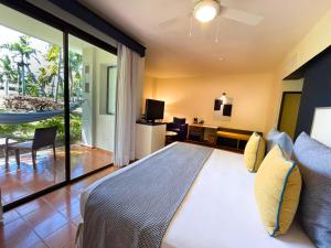 a bedroom with a large bed and a balcony at Catalonia Punta Cana - All Inclusive in Punta Cana