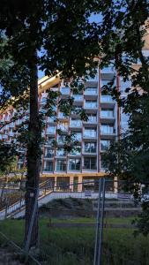 a large apartment building with a tree in front of it at PINEA BALTIC - 2 Zimmer Apartment mit Meerblick in Pobierowo