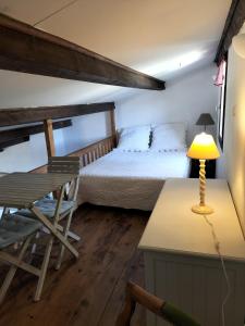 um quarto com uma cama e uma secretária com um candeeiro em les aires em Sainte-Croix-de-Verdon