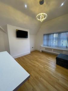 ein leeres Wohnzimmer mit einem Sofa und einem TV in der Unterkunft Penthouse APT 7 in Wolverhampton